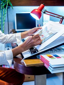 Interior designer's hand working with illustration sketch on desk